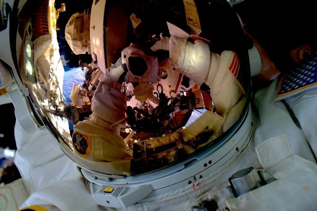 Astronaut helmet reflecting space and Earth.