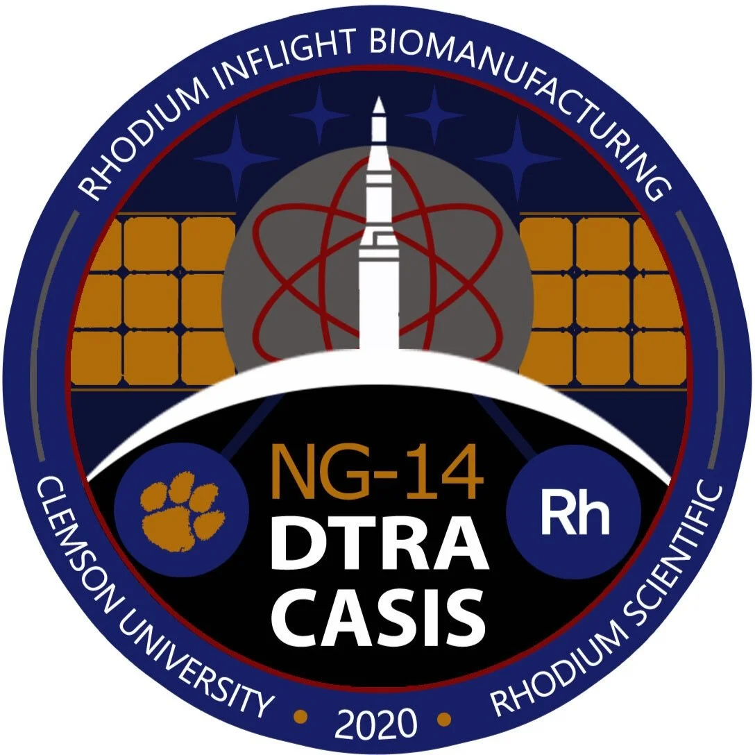 Space mission patch with scientific symbols.