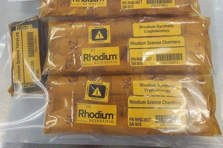 Rhodium Scientific packages with labels on table.
