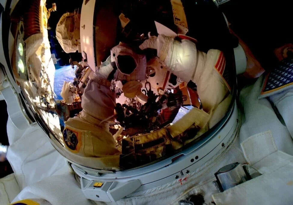Astronaut helmet reflecting space and Earth.